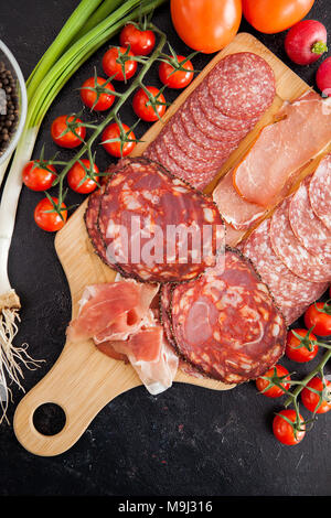 Vue de dessus sur différents types de tranches de jambon, salami et proscuitto Banque D'Images