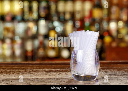 Beaucoup de pailles pour les cocktails dans un verre transparent sur la barre dans une discothèque, un bar, l'espace d'arrière-plan flou pour le texte Banque D'Images