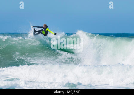 Un internaute effectuant un tour spectaculaire en haut d'une vague à l'dans Fistral Newquay Cornwall. Banque D'Images