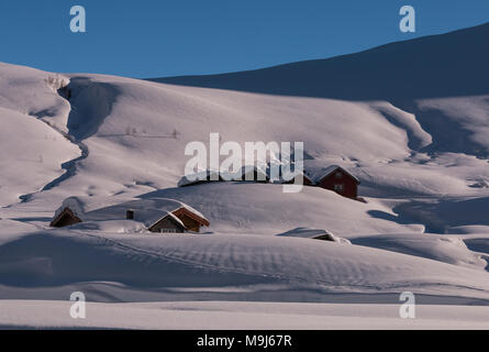 La montagne de neige immaculée avec winterscape et enterré chalets montrant les pâturages de montagne à l'hiver Banque D'Images