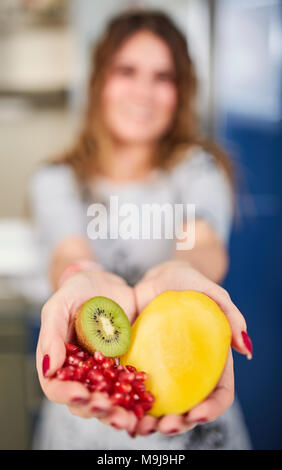 Femme offrant des fruits exotiques, son visage est en arrière-plan flou Banque D'Images