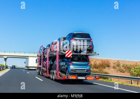 Remorque porte-voiture avec des voitures sur la plate-forme superposés. Transport de voiture camion sur l'autoroute. Pont de l'autoroute. Un espace réservé au texte Banque D'Images