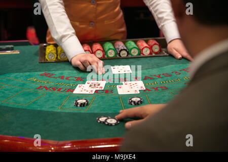 Le concessionnaire met une carte sur table de blackjack Banque D'Images