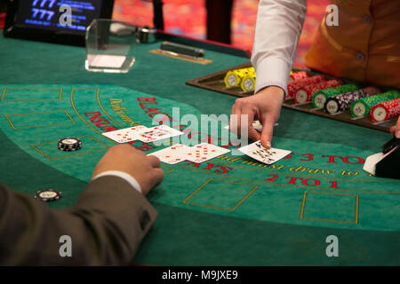 Le concessionnaire met une carte sur table de blackjack Banque D'Images