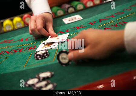 Le concessionnaire met une carte sur table de blackjack Banque D'Images