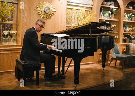 Le Pianiste jouant un beau piano Steinway in London's Fortnum et Mason entrée Salon de Thé Banque D'Images