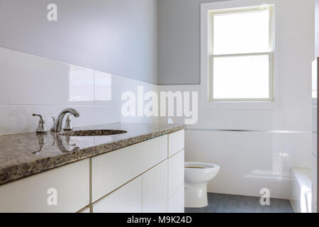 La salle de bains principale en nouvelle construction maison avec de grandes armoires en bois salle de bain en marbre blanc de luxe dans un coûteux accueil Banque D'Images