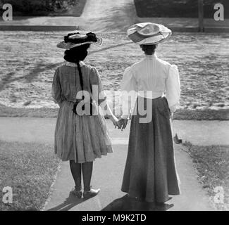 Deux femmes victoriennes visage et tenir la main, ca. 1900. Banque D'Images