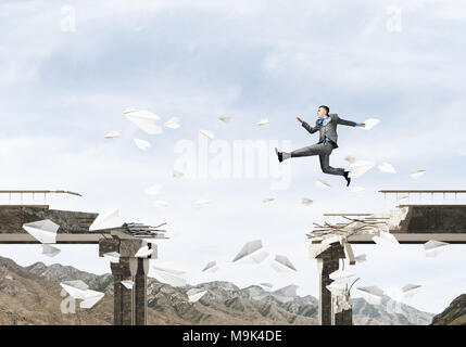 Businessman jumping over gap en pont entre flying paper planes comme symbole de surmonter les difficultés. Skyscape et nature vue sur arrière-plan. 3D render Banque D'Images