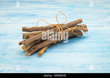 Ensemble de racines de réglisse Glycyrrhiza glabra sur table rustique Banque D'Images