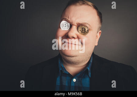 Man holding jeton Bitcoin pièces de monnaie jusqu'à ses yeux. Banque D'Images