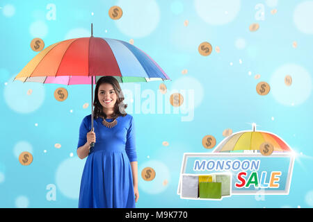 Belle asian woman holding umbrella avec rainy pièce d'or. Concept vente de mousson Banque D'Images