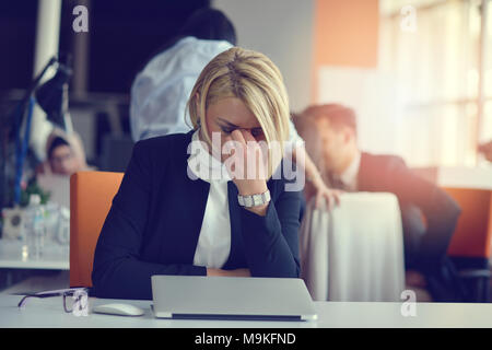 Se sentir fatigué et stressé. Femme adulte frustré en gardant les yeux fermés de fatigue alors qu'il était assis dans le bureau. Banque D'Images