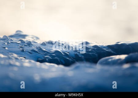 Un beau gros plan d'une eau de mer gelée sur la côte de la mer Baltique. Vagues d'eau salée gelées sur une plage. Gros plan abstrait de glace. Banque D'Images