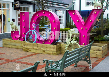 Un grand panneau sur un mur pignon à l'entrée de la prestigieuse Kildare Village retail park dans le comté de Kildare en Irlande Banque D'Images