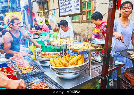 YANGON, MYANMAR - février 14, 2018 : des stands de nourriture de rue et de petits cafés en plein air sont très populaires dans le quartier chinois, les cuisiniers locaux offrent des légumes, viandes épicées Banque D'Images