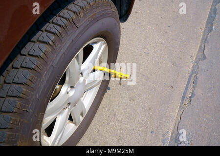 Roue de voiture bloquée par blocage de roue parce que le stationnement illégal violation Banque D'Images