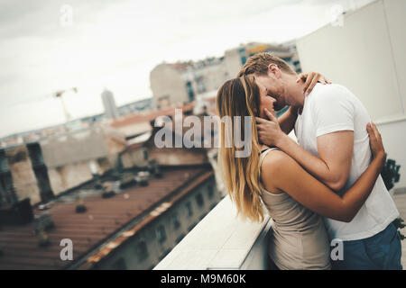 Couple kissing on rooftop Banque D'Images