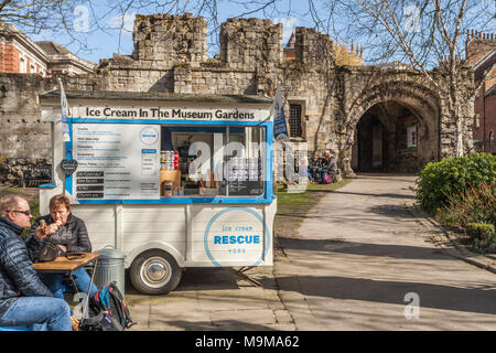 Un couple assis bénéficiant d'une glace à côté du vendeur dans les jardins du Musée de York, North Yorkshire, Angleterre, Royaume-Uni Banque D'Images