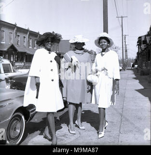 Années 1960, Philadelphia, USA, trois superbes, élégantes et bien-habillés chers sur une journée debout sur le trottoir dans la ville, le port de chaussures à la mode, manteaux et chapeaux et à plutôt chic. Banque D'Images