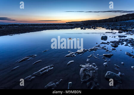 Llantwit Major plage juste après que le soleil s'est caché derrière la falaise sur une belle soirée en Mars Banque D'Images