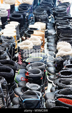 Soixante cinq paires de bottes d'hiver parfaitement alignées dans une station de ski du Québec Banque D'Images