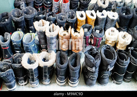 Soixante cinq paires de bottes d'hiver parfaitement alignées dans une station de ski du Québec Banque D'Images