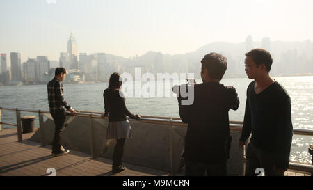 Hong Kong, Chine - 1 janvier 2016 : les personnes dans le port de Victoria à Hong Kong. Vue sur la mer et la ville de l'pont. Le photographe fait un parcours professionnel photo. Banque D'Images