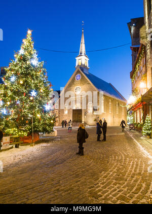 Notre Dame des Victorires et l'arbre de Noël : la petite église dans la section touristique de Québec inférieur avec un grand sapin de Noël allumé sur la place. Regarder les touristes et d'errer. Banque D'Images