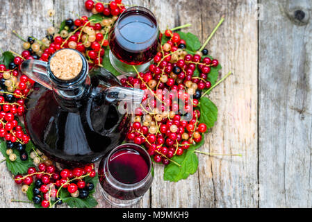 Liqueur de fruit dans une bouteille et verre de l'alcool doux sur table en bois Banque D'Images