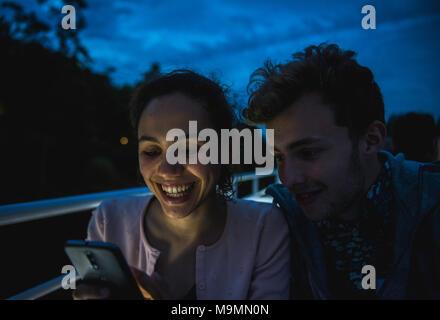 Jeune couple à la recherche à l'écran d'un téléphone portable, Smartphone, Berlin, Allemagne, Selfies Banque D'Images