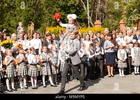 Tioumen, Russie - septembre 1, 2017 : gymnase numéro 5. Garçon plus âgé, adolescent, de race blanche, porte petit écolière avec la cloche. Première sonnerie à new scho Banque D'Images