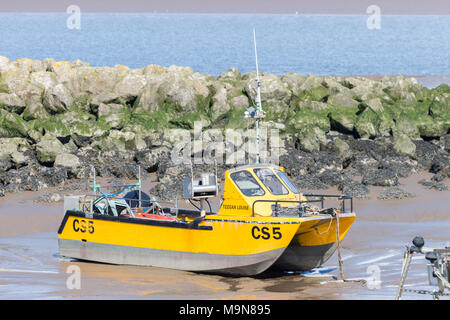 Un petit bateau de pêche côtière est échoué et l'attente de la marée basse à Morecambe, England, UK Banque D'Images