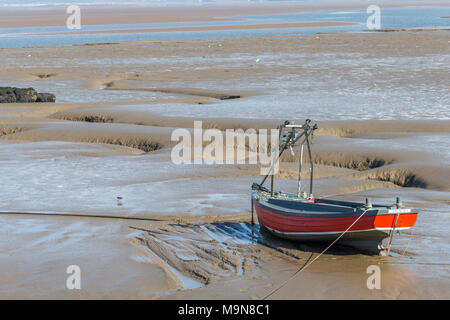 Un petit bateau de pêche côtière est échoué et l'attente de la marée basse à Morecambe, England, UK Banque D'Images