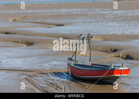 Un petit bateau de pêche côtière est échoué et l'attente de la marée basse à Morecambe, England, UK Banque D'Images