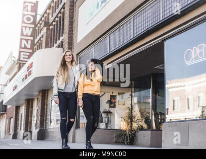 Deux jolies jeunes filles rire et marcher dans une rue au centre-ville Banque D'Images