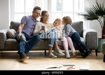 Heureux en famille avec enfants shopping avec mobile app ensemble, smiling young couple l'achat en ligne à l'aide de smartphones avec les enfants, les parents d'un Banque D'Images