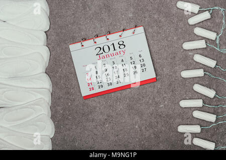 Vue de dessus, les tampons tampons menstruels arrangé et calendrier sur surface grise Banque D'Images