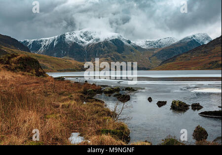 Une glaciale Llyn Ogwen Tryfan enneigés avec une montagne à l'arrière. Banque D'Images