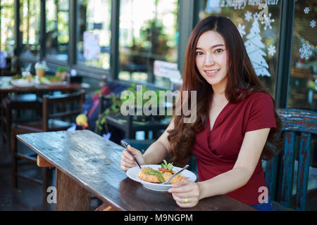 Young woman eating food in a restaurant Banque D'Images