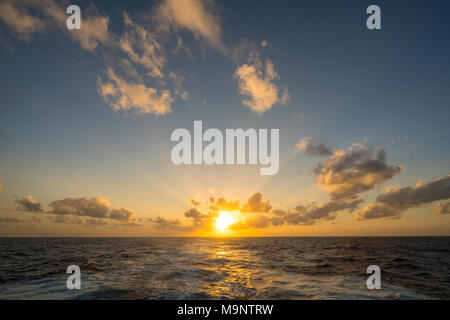 Coucher de soleil derrière un bateau de croisière en mer croisière Banque D'Images