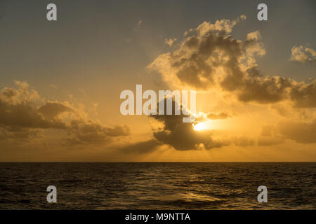 Coucher de soleil derrière un bateau de croisière en mer croisière Banque D'Images