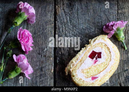 Rouleau de pâte à biscuit, de canettes et fleurs oeillet rose sur fond en bois, vintage - mise à plat fond alimentaire Banque D'Images