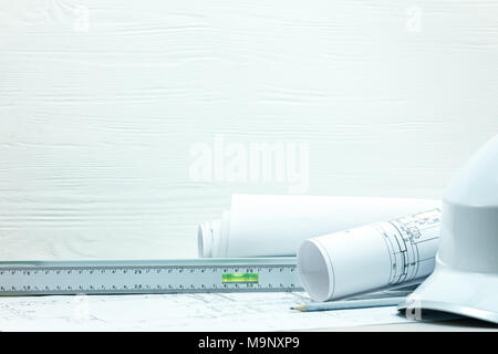 Lieu de travail bureau d'architectes, des outils d'ingénierie. dessins du projet et plans, casque de protection contre l'arrière-plan en bois blanc. Banque D'Images