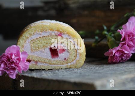 Rouleau de pâte à biscuit, de canettes et fleurs oeillet rose sur fond en bois, vintage - mise à plat fond alimentaire Banque D'Images