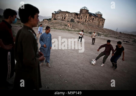 De jeunes Afghans jouer au soccer comme bombardé le Palais Darul Aman qui signifie 'havre de paix', détruit pendant la guerre civile à Kaboul, Afghanistan, le mercredi, 15 juillet 2009. Banque D'Images