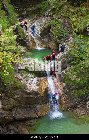 Canyoning dans une gorge étroite remplie de rapids, piscines et cascades dans la vallée de Soca près de Bovec, Slovénie. Banque D'Images