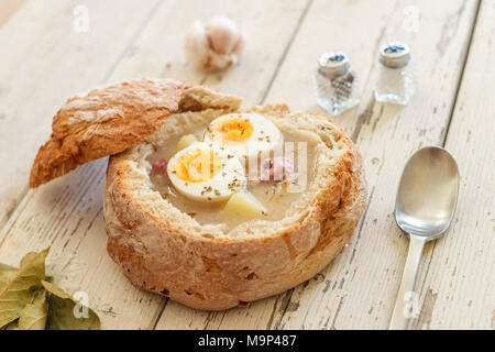 Soupe Zurek polonais traditionnel appelé avec des œufs et des saucisses sur fond de bois Banque D'Images