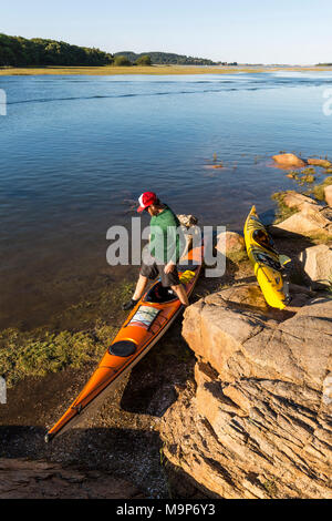 L'homme et la paire de kayaks à côté de la rivière d'Essex à Cox Reservation dans l'Essex, Massachusetts Banque D'Images