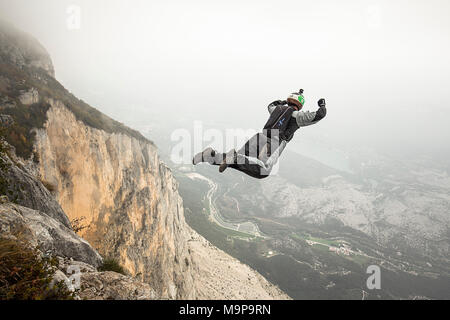 Cavalier Base mid air juste après cliff jump pendant temps de brouillard, Brento, Vénétie, Italie Banque D'Images